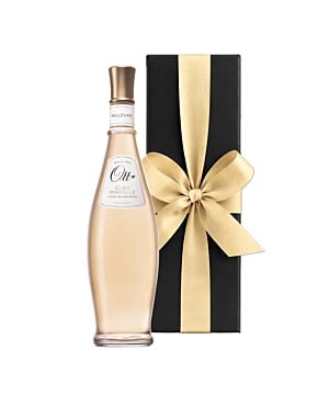 A bottle of Domaine Ott Clos Mireille Rosé in its iconic amphora shape, standing next to a luxury black gift box finished with a large, hand-tied ribbon.