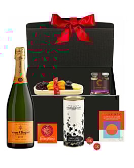 Luxury Veuve Clicquot Champagne Christmas hamper with chocolates, festive treats, and ribbon-tied gift box.